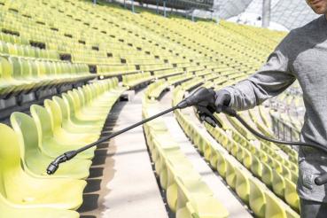 Anwendung des MESTO CLEANER E10 zur Flächenreinigung auf Stadion-Sitzreihen – gezielter Auftrag von Reinigungslösung mit ergonomischem Abstellventil.