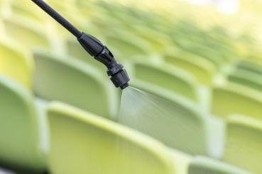 Feiner Sprühstrahl der Flachstrahldüse des MESTO CLEANER F10 beim Einsatz auf Stadion-Sitzreihen – gleichmäßige Flächenbenetzung.